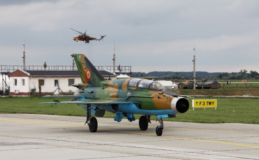 Rumuński MiG-21 Lancer kołuje po pokazie, w tle prezentuje się Mi-24