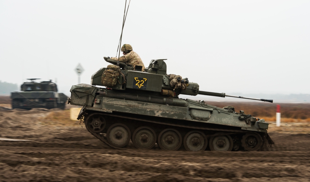 Lekki czołg rozpoznawczy Scimitar pędzi, ile sił w gąsienicach. W tle polski Leopard 2 (fot. SSgt Mark Nesbit RLC (Phot), © MOD / Crown Copyright)